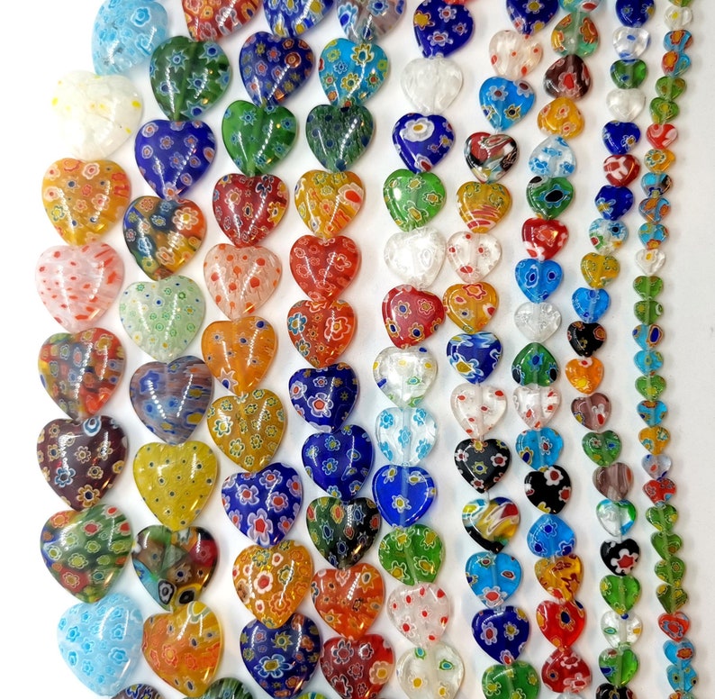 May include: A collection of colorful heart-shaped glass beads with intricate patterns. The beads are strung together on a string and are perfect for jewelry making or crafting.