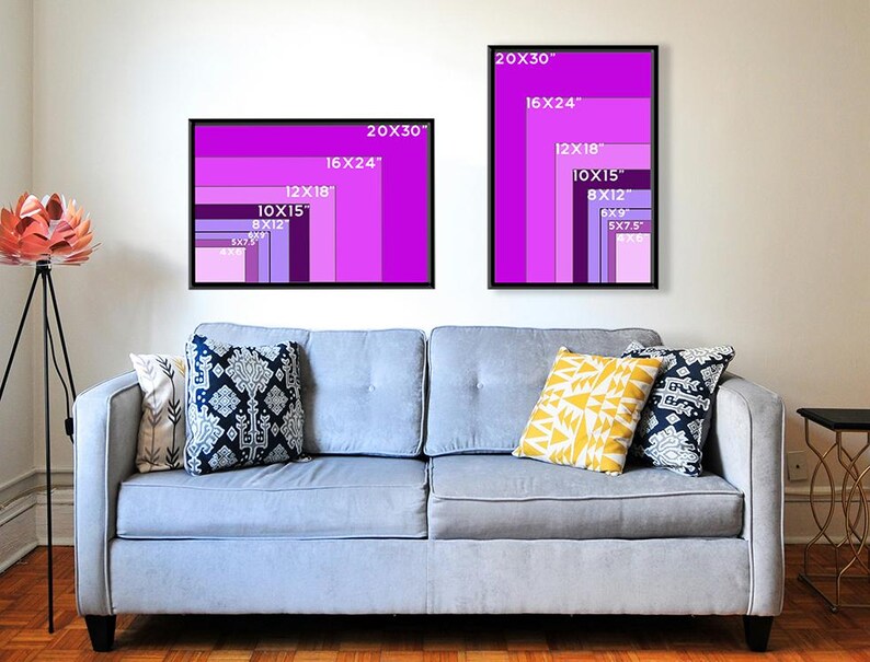 May include: Two framed art prints with a gradient of purple shades, labelled with dimensions in inches. The prints are displayed above a light blue sofa with decorative cushions. The text on the prints includes sizes such as 20x30, 16x24, 12x18, 10x15, 8x12, 6x9, and 5x7.5.