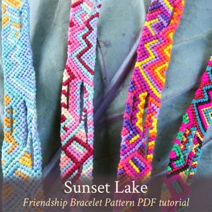 May include: Four colorful friendship bracelets with a chevron pattern in shades of blue, pink, purple, and green. The bracelets are laid out on a purple background with the text "Sunset Lake Friendship Bracelet Pattern PDF tutorial".