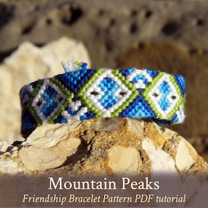 以下が含まれることがあります： 青、緑、白の幾何学模様の友情ブレスレット。ブレスレットの名前は「Mountain Peaks」で、PDFチュートリアルです。