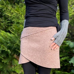 Könnte beinhalten: Ein brauner Wickelrock mit einem langen schwarzen Shirt und braunen kniehohen Stiefeln.