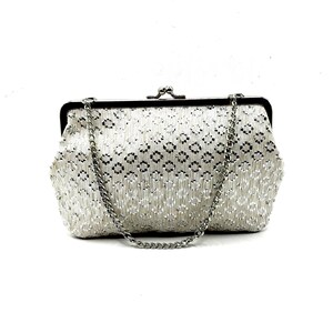 May include: A silver-toned clutch bag featuring a repeating geometric diamond pattern in white and metallic silver. The bag has a rectangular frame with a kiss-lock closure at the top and includes a detachable silver-toned metal chain shoulder strap.