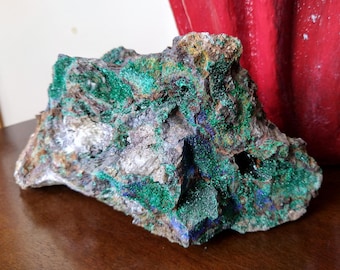 May include: A large, rough, green and blue rock with a sparkly, crystalline texture. The rock has a variety of shades of green and blue, and some areas are a darker brown color.