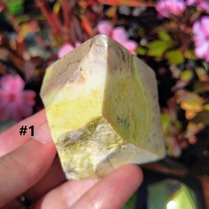 Könnte beinhalten: Ein polierter Stein in Grün, Gelb und Weiß mit rauer, natürlicher Textur. Der Stein ist würfelförmig mit abgerundeten Kanten. #1