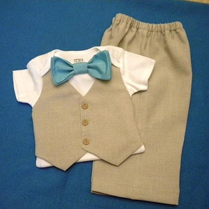 May include: A baby outfit set with a white onesie, a beige vest, and beige pants. The onesie has a blue bow tie.