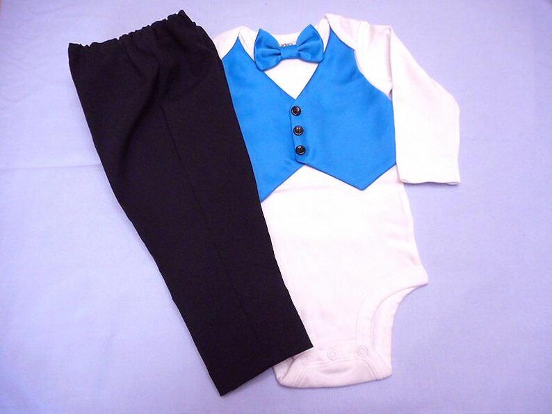 Może przedstawiać: Biały body z niebieską kamizelką i czarnym krawatem. Kamizelka ma czarne guziki. W zestawie czarne spodnie.