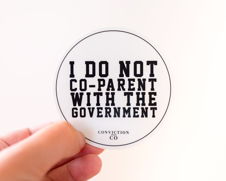 May include: White round sticker with black text that reads "I do not co-parent with the government." The sticker also has the text "Conviction Co" in smaller black text.
