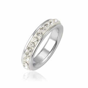 May include: A silver ring with a row of clear crystals around the band.