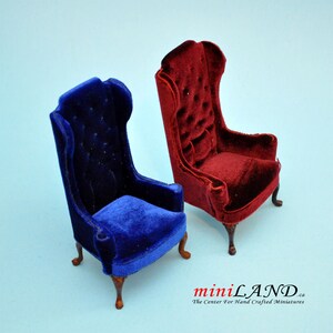 May include: Two miniature velvet chairs, one in a deep blue and the other in a rich burgundy red. Both chairs have a classic wingback design with tufted upholstery and wooden legs.