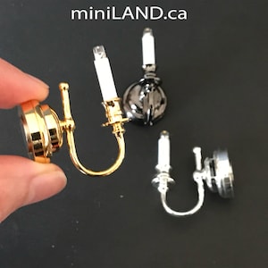 Peut inclure: Trois appliques murales miniatures avec des ampoules en forme de bougie. Les appliques sont en finition or, argent et noir.