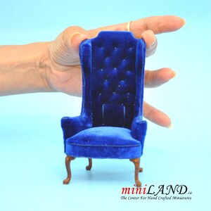 May include: A miniature blue velvet armchair with a high back and tufted upholstery. The chair has a classic design with cabriole legs and a scrolled top.