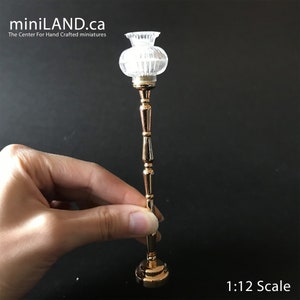 Peut inclure: Un lampadaire doré avec un abat-jour en verre transparent. La lampe est à l'échelle 1:12.