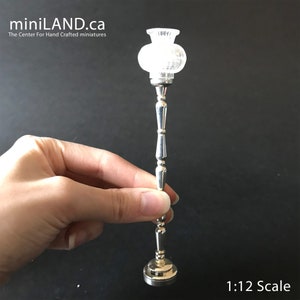 May include: Silver floor lamp with a clear glass shade. The lamp is 1:12 scale.