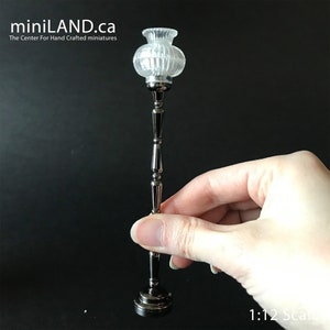 May include: A silver floor lamp with a clear glass shade. The lamp is 1:12 scale.