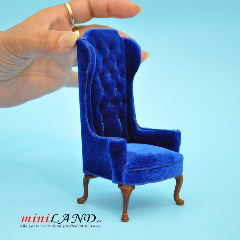 May include: A miniature blue velvet armchair with a tufted back and cabriole legs. The chair is approximately 1:12 scale.