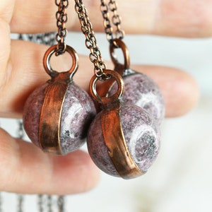May include: Three necklaces with copper chain and round, purple and white stone pendants.