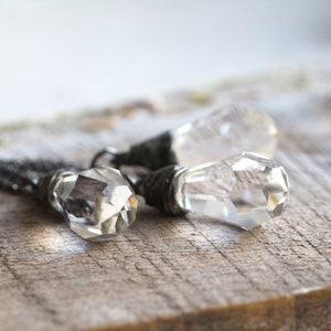 May include: Two crystal teardrop pendants with silver wire wrapped around the top of each pendant.