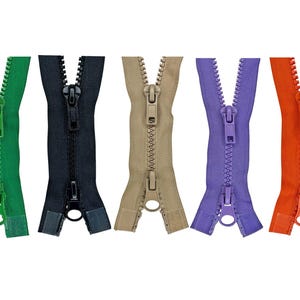 May include: Five colorful zippers in green, black, tan, purple, and orange are displayed against a white background. Each zipper is open, showcasing the teeth and pull tab. The zippers are made of plastic and are likely for clothing or craft projects.