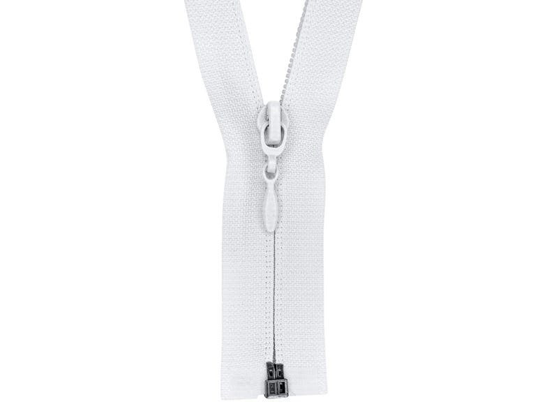 May include: A white zipper with a metal slider and pull tab. The zipper is closed and the slider is in the centre of the zipper.