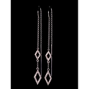 以下が含まれることがあります： ダイヤモンド型のチャームが2つ付いた、シルバーのドロップイヤリングのペア。チャームは小さなクリアストーンで作られています。