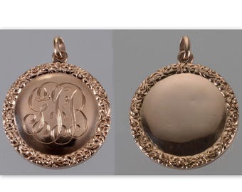 May include: Two rose gold pendants. One pendant features an engraved monogram within a decorative border. The other pendant has a plain surface. Both pendants have a loop at the top for a chain.