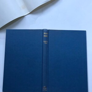 May include: A blue hardcover book with the title "Billy Buck" and the author "James A. Michener" printed in gold on the spine.
