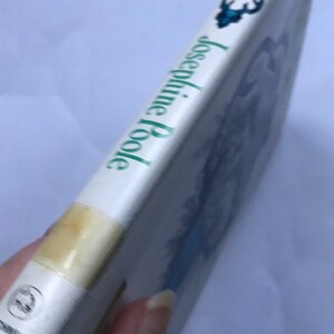 May include: A white book with a green title that reads "The Black Tulip" by Josephine Poole. The book cover features a blue and white illustration of a tulip.