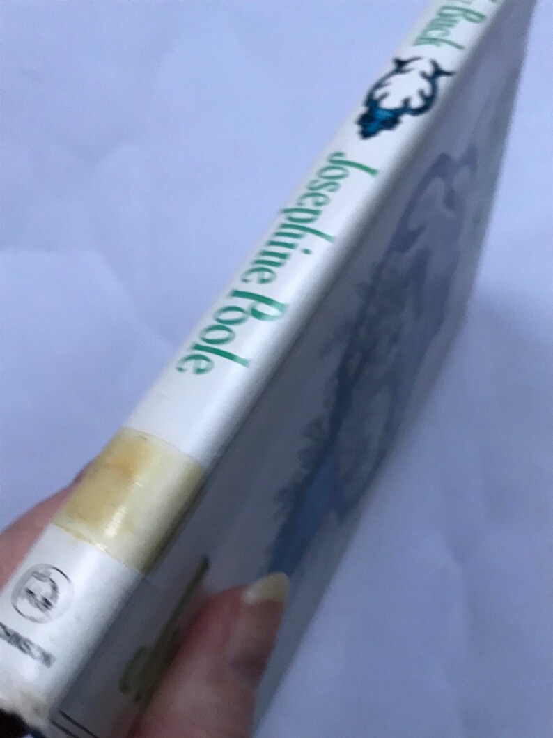May include: A white book with a green title that reads "The Black Tulip" by Josephine Poole. The book cover features a blue and white illustration of a tulip.