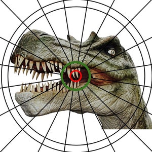 May include: A dartboard with a green and red bullseye featuring a dinosaur head with sharp teeth. The dinosaur head is in the center of the dartboard.