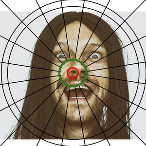 May include: A close-up of a person's face with a green circle around the nose and a red circle around the nostril. The person has long dark hair and is looking directly at the camera with a surprised expression.