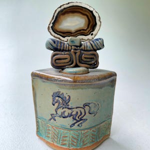 Recipiente de cerámica artesanal con forma de caballo y tapa de ágata pulida: arte cerámico único para la decoración del hogar.