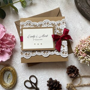 Handgemachte Hochzeitseinladung Muster. Im rustikalen Stil mit Spitze, weinrotem Band & Perlen. Inklusive RSVP Karte, Gästeinfo und Menü/Geschenkgedicht