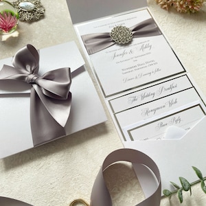 Atemberaubendes Muster einer handgemachten Hochzeitseinladung von Olivia | Elegante Schleife und Kristallverzierung