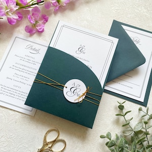 Suite d'invitations vert forêt arquées avec monogramme circulaire, invitation, RSVP et carte d'information. Avec enveloppes