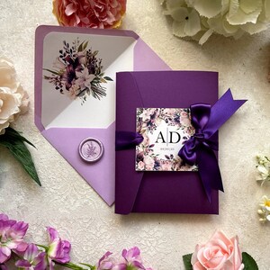 Ensemble d'invitations de mariage violet. Pliage de poche avec carte RSVP/informations invité. Jolie et élégante. Ruban, lys. Échantillon non personnalisé.