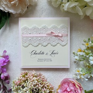Echantillon de faire-part Blush. Avec de la dentelle de style vintage, un ruban de satin et un noeud. Design féminin délicat. Comprend une carte RSVP, des informations sur les clients et un menu.