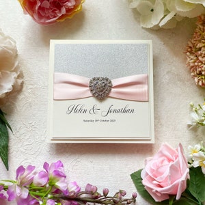 Glitzer-Hochzeitseinladungs-Muster. Mit rosa Satinband & Herzverzierung. Inklusive Antwortkarte, Gästeinfo und Menü.