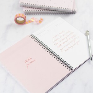 A close up of the ivf planner open at the test page, there is a quote that reads 'think positive' and a quote that reads 'every story comes to an end, take a deep breath and turn the page your next chapter is waiting for you'.