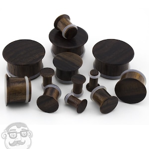 May include: A set of wooden ear gauges in various sizes, ranging from small to large. The gauges are made of dark brown wood with a natural grain pattern. They are designed for stretched earlobes and come with a variety of sizes to accommodate different earlobe sizes.