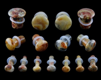 May include: Set of agate stone ear gauges in various sizes. The gauges are a mix of brown, white, and yellow colors with a marbled pattern. 