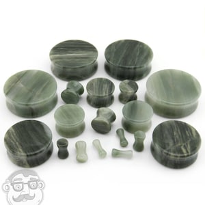 May include: A set of green and white striped stone ear gauges in various sizes. The gauges are made of natural stone and have a smooth, polished finish.