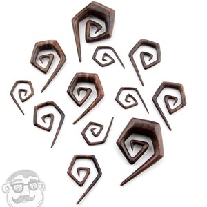 May include: A set of 12 wooden spiral ear gauges in various sizes. The gauges are made of dark brown wood and have a unique spiral design.