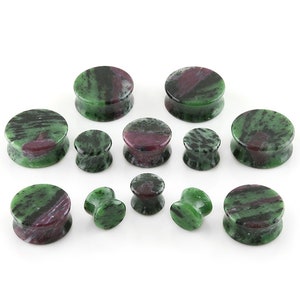 May include: Set of green, black, and purple stone ear gauges in various sizes.