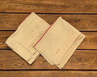 May include: Two off-white linen tea towels with red trim and embroidered initials "S.W."