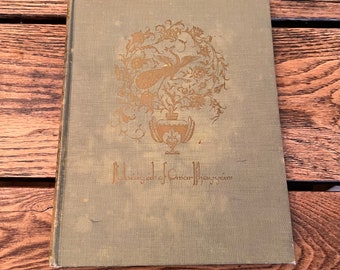Könnte beinhalten: Ein grünes Buch mit einem goldenen Design auf dem Einband. Das Design zeigt eine Vase mit Blumen und einem Vogel. Der Titel des Buches lautet "Rubaiyat von Omar Khayyam".