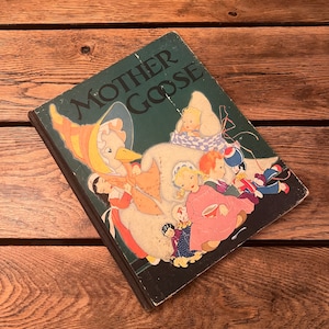 May include: A vintage children's book titled "Mother Goose" with a green cover and a colorful illustration of a goose and children on the front.