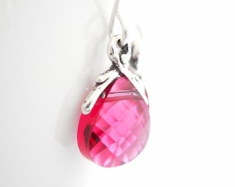 May include: A pair of silver dangle earrings with a pink faceted teardrop crystal.