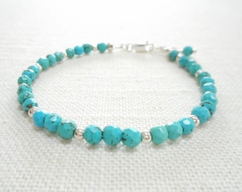 May include: A turquoise gemstone bracelet with silver beads and a silver clasp.