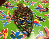 Vintage hand painted heavy black cast iron 252 trivet with floral designs