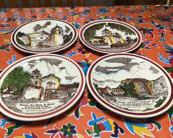 Könnte beinhalten: Set aus vier Vintage-Keramiktellern mit Illustrationen von kalifornischen Missionen. Jeder Teller hat einen roten und weißen Rand und zeigt eine andere Mission mit ihrem Namen und Gründungsdatum. Die Teller sind in ausgezeichnetem Zustand.